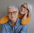 Older man and woman happy with eye exam and glasses